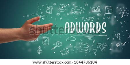 Close-Up of cropped hand pointing at ADWORDS inscription, modern business solution concept