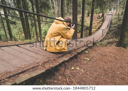 photographer traveler on a suspension bridge in forest wild extreme journey 