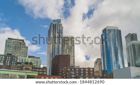 urban high-rises against clouds on a parlty sunny day