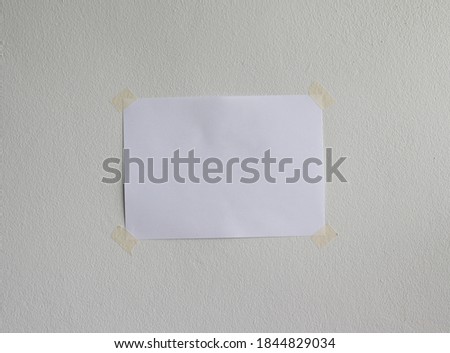 sheet paper with adhesive tape on concrete wall