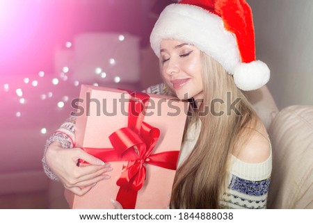 Beautiful blonde in a new year's image with a gift box in her hands