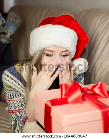 Beautiful blonde in a new year's image with a gift box in her hands