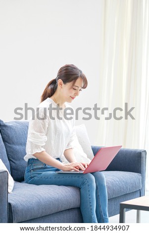 Asian woman using the PC on the sofa