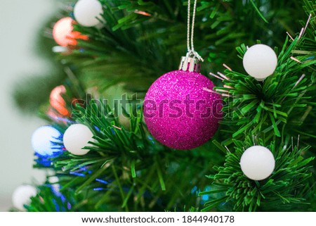Close up view on a pink ball toy on a  Christmas tree (selective focus, shallow depth of field)