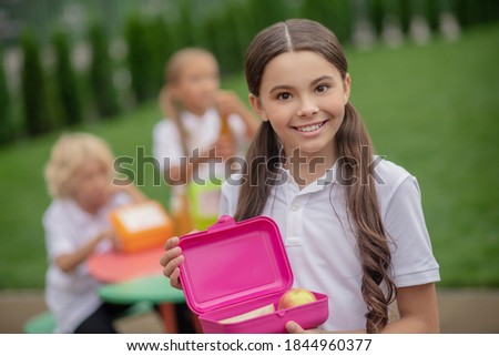 Lunch. A girl with a lunch box smiling nicely Royalty-Free Stock Photo #1844960377