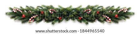 Christmas border frame of tree branches with red balls, pine cones and candies Royalty-Free Stock Photo #1844965540