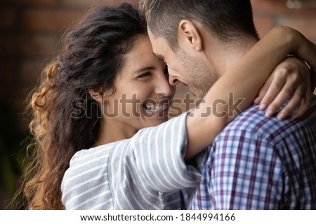 Close up of happy young Caucasian couple hug and cuddle enjoy tender close romantic moment together. Smiling millennial man and woman embrace show love and care in relationship. Marriage concept. Royalty-Free Stock Photo #1844994166