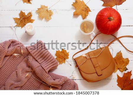 autumn still life, yellow leaves, pumpkin, candles, knitted sweater on a white background, top view