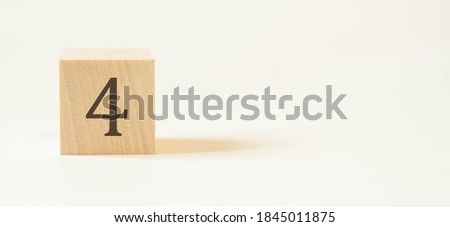 Number four on a wooden cube with a white background.