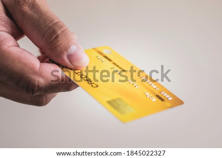 A man hand holding yellow gold credit card, financial business and online marketing concept, shopping credit card payments