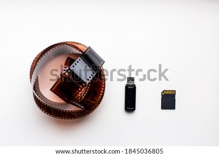 
35mm film and compact flash memory card on white background. present and past concept