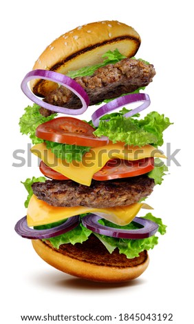 Big delicious hamburger cheeseburger flying on white background