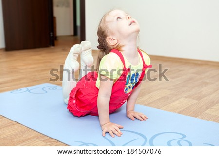 Flexible Caucasian girl exercising on mat.