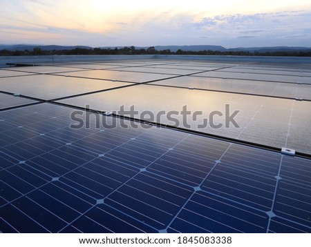 Solar Panels Blue and Gold on Flat Roof, with a Sunset Reflection of with Warm tones reflecting in the Solar Panels. 