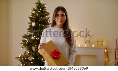 Portrait Of Cheerful Young Caucasian Woman Happy and Excited Standing During Christmas With Gift Mother Of Family, Christmas Time At Home Holidays And Celebrations Concept