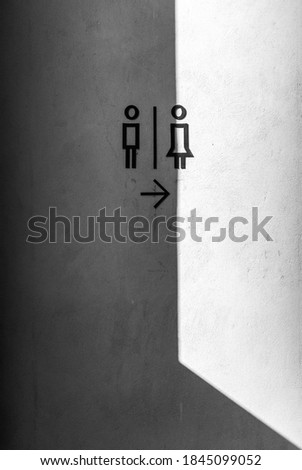 Black outline of toilet sign on concrete background with shadow