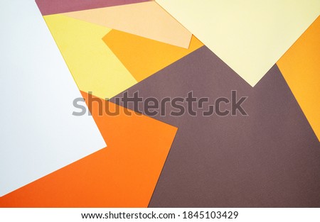 Multi colored abstract paper of pastel yellow, orange,brown colors palette, with geometric shape, flat lay.