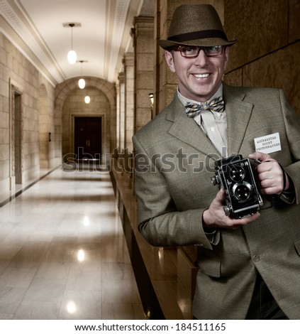 Photographer in vintage retro clothing holding old camera