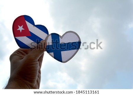 Hand holds a heart Shape Cuba and Finland flag, love between two countries