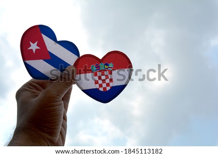 Hand holds a heart Shape Cuba and Croatia flag, love between two countries