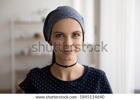 Head shot portrait attractive hairless woman wearing head scarf, beautiful young female with stylish makeup looking at camera, happy patient with cancer in remission, healthcare concept