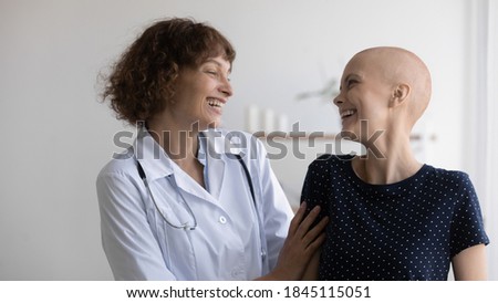 Close up overjoyed doctor and hairless woman laughing, celebrating success, remission, successful treatment and healthcare concept, caring specialist supporting patient struggling with oncology Royalty-Free Stock Photo #1845115051
