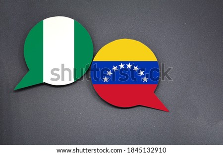Nigeria and Venezuela flags with two speech bubbles on dark gray background