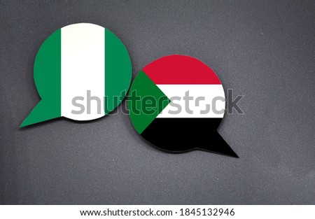 Nigeria and Sudan flags with two speech bubbles on dark gray background