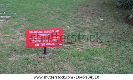 "Don't step on the grass" sign , Warning sign that warns to don't step on the grass. The sign on the label "do not walk" on a green lawn. 