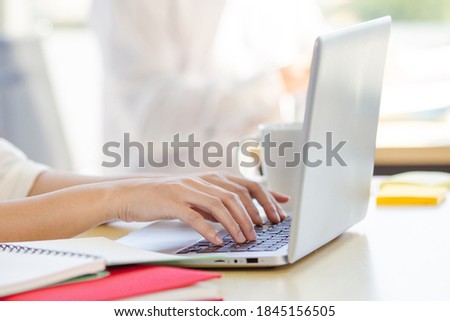 Woman working in the office by using personal laptop computer close up, close up on a hands on computer keyboard. Office woman using laptop computer for sending an email and social media