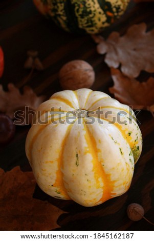 Thanksgiving background : pumpkins, autumn leaves, nuts on wooden background. Thanksgiving, Halloween or seasonal autumn concept. Top view, side view, toned