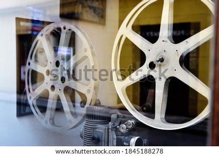 Real classic movie reel with reflection of movie posters