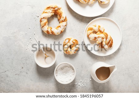 Bakery concept, sweet round desserts with glazed sugar on the light background. Top down view.