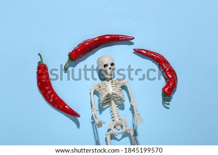 Skeleton and red chili peppers on a blue background