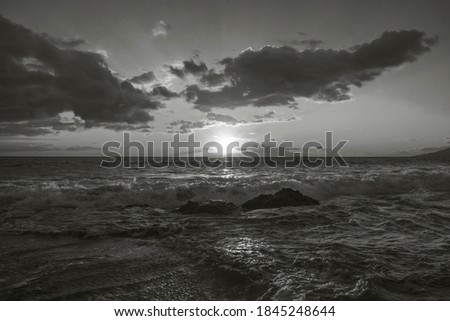 This black and white photograph was taken during the sunset in Kihei, Maui, Hawaii. The strong sunlight with the dramatic clouds forms a beautiful photograph. 