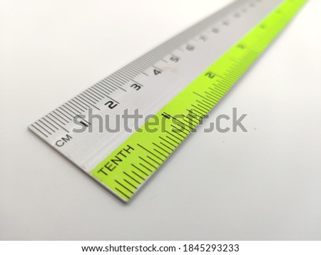 a long plastic ruler with metric and imperial measurements scale. Slightly burred at the back end