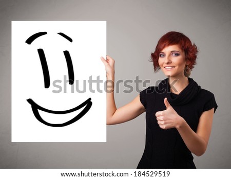 Attractive young woman holding smiley face drawing