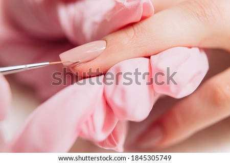 Manicure process. Manicurist paints fingernails. Nail polish. Royalty-Free Stock Photo #1845305749