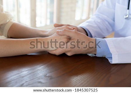 Hard diagnosis is not verdict. Close up of man doctor holding woman customer hands with care compassion support, confident qualified medical specialist convincing encouraging patient to take treatment Royalty-Free Stock Photo #1845307525