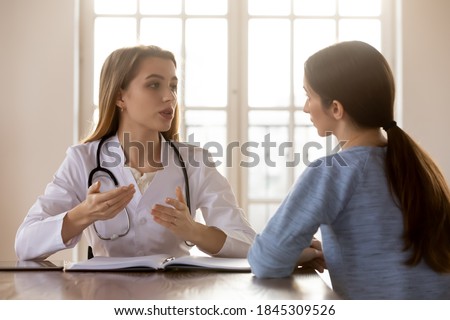I recommend you to do next. Tactful confident millennial female physician in charge receiving consulting young woman patient, diagnoses her, proposing tactics of treatment cure, giving prescriptions Royalty-Free Stock Photo #1845309526