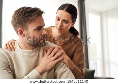 Can I help you? Supportive woman embracing her depressed husband helping sharing grief or problem. Apology, compassion, empathy in couple relationships concept