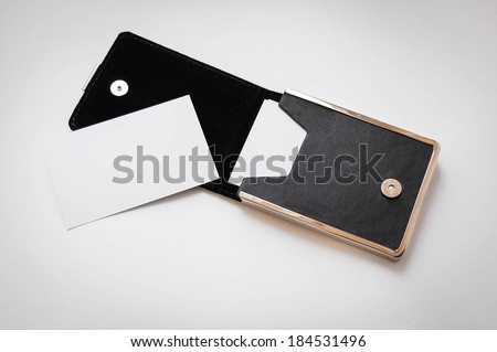 a business card and a black card holder on white background