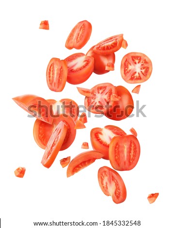 Sliced tomato pieces falling isolated on a white background