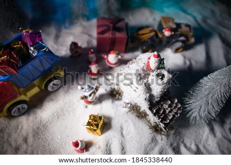 Miniature Gift Box by Forklift Machine on snow ,Determined Image for Christmas Holiday and Happy New Year Gift Celebration concept. Empty space for text