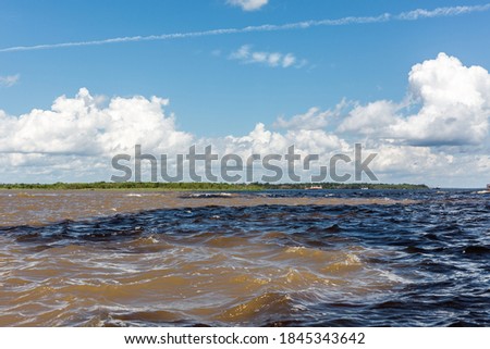 The Meeting of Waters (Encontro das Águas) where the Rio Negro and the Amazon River mix together, referred to as the Solimões River, near Manaus in the State of Amazonas, Brazil, South America
