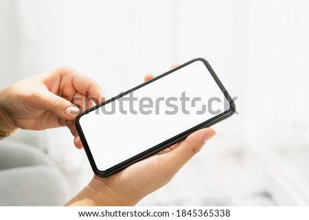 Woman hand holding smartphone and the screen is blank, social network concept, copy space for your advertising.