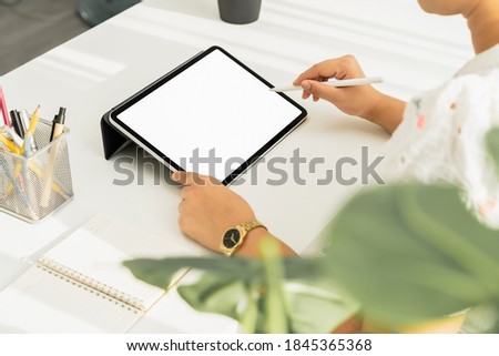 woman hand using digital tablet on the table and the screen is blank.