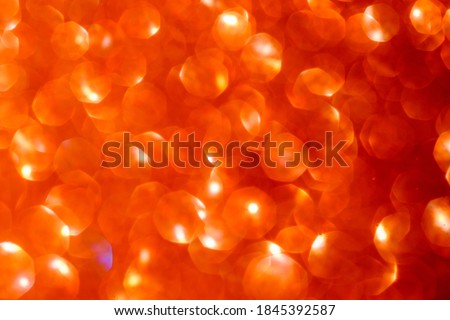 Defocused lights. Bright orange flat hexagon lights bokeh on black background. Golden glitter Christmas abstract background.