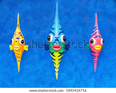 Funny cartoon colorful fish sculpture on wall