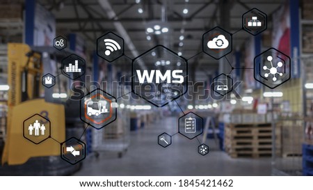 Inscription WMS on blurred warehouse background. Werehouse Management System. Royalty-Free Stock Photo #1845421462
